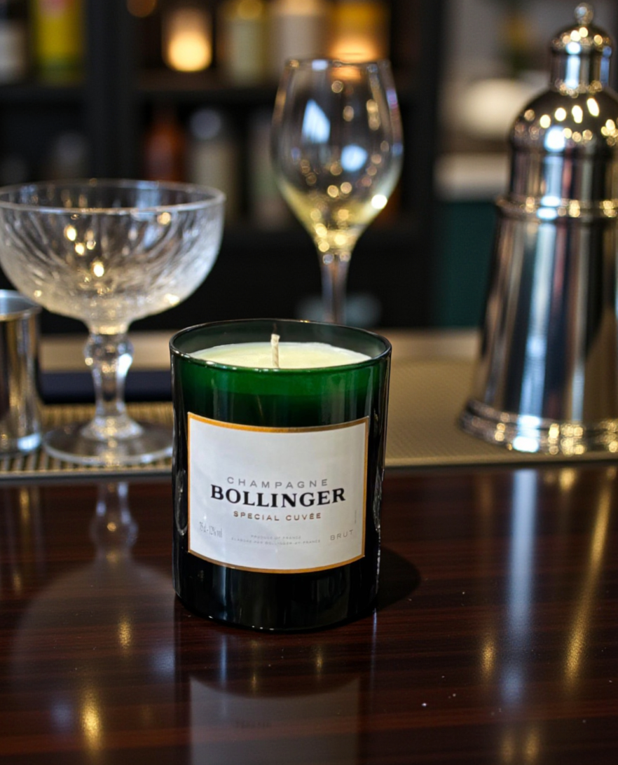 Bollinger champagne candle on a bar with wine glasses and bottles in the background