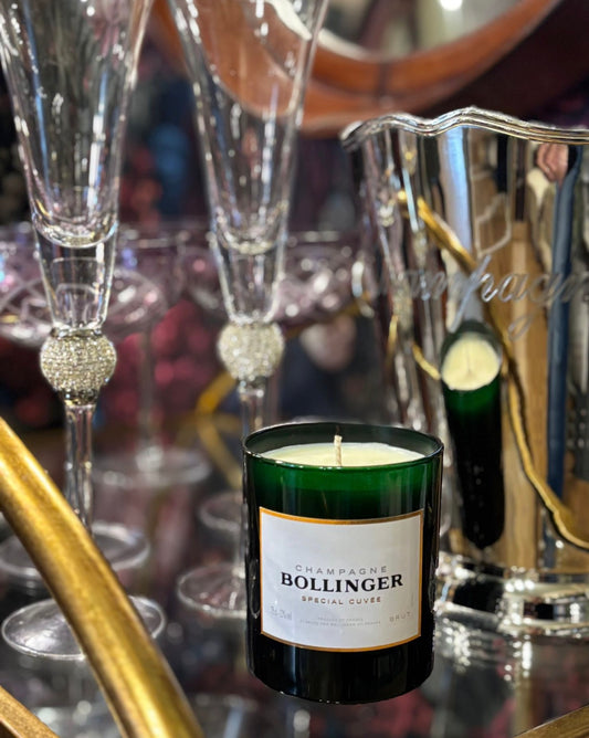 Bollinger champagne candle with champagne flutes and silver pitcher in the background